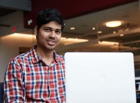Male international student studies at his laptop